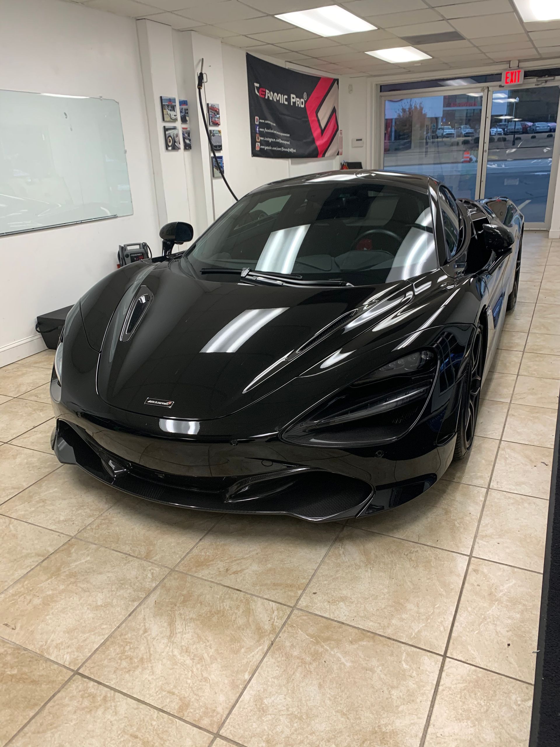 A black sports car is parked in a garage.