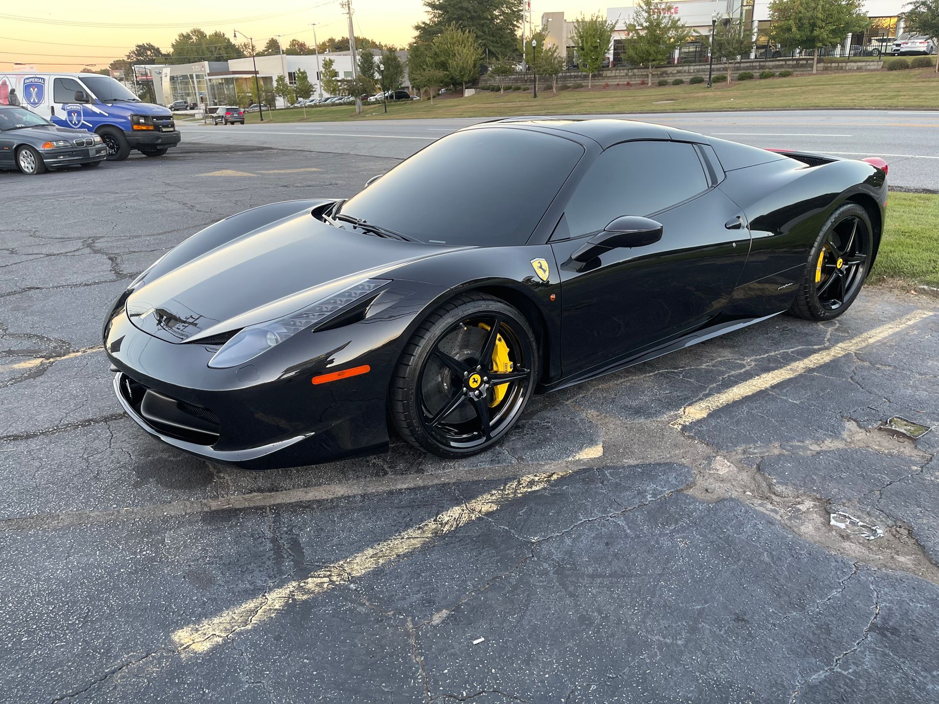 A black Ferrari is parked in a parking lot.