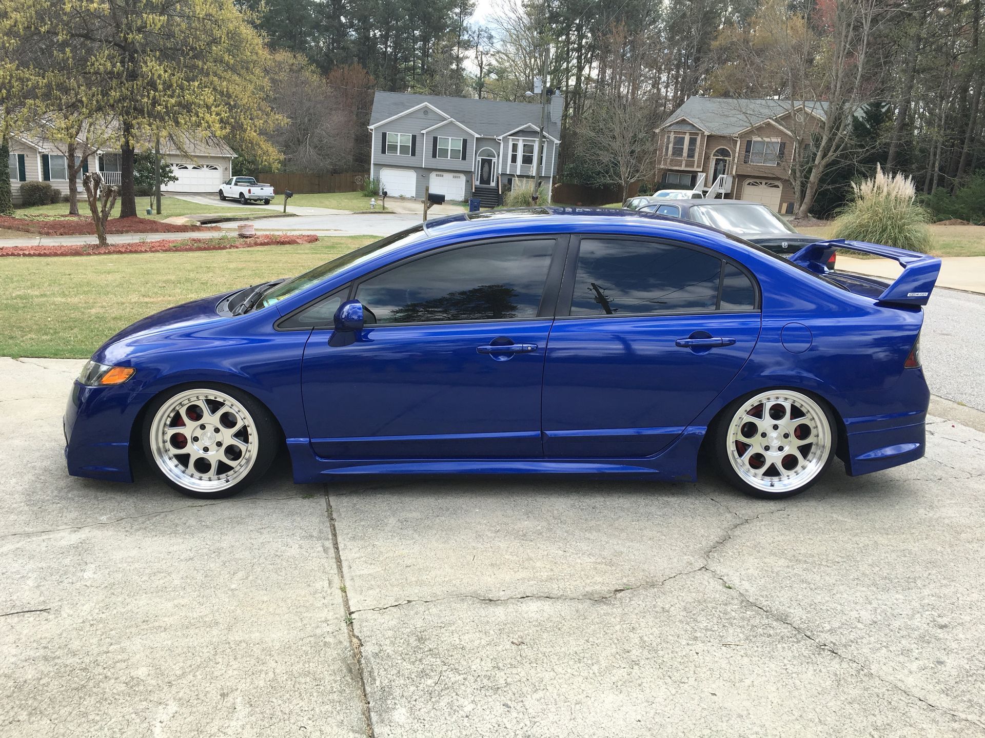 A blue Honda Civic is parked on the side of the road.