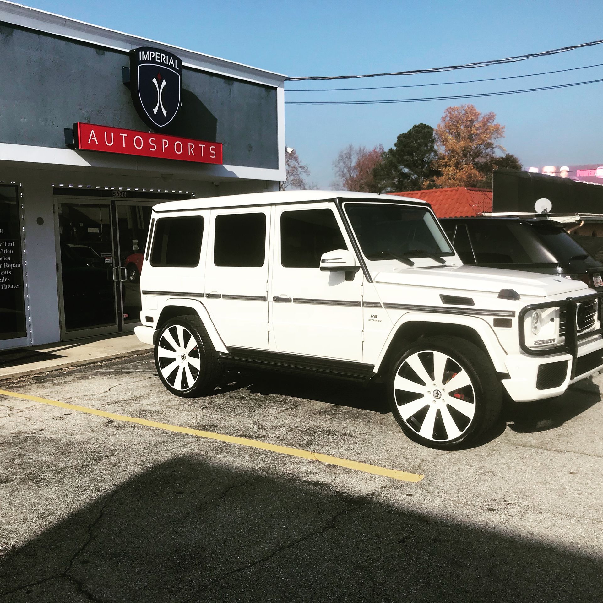A white SUV is parked in front of a building