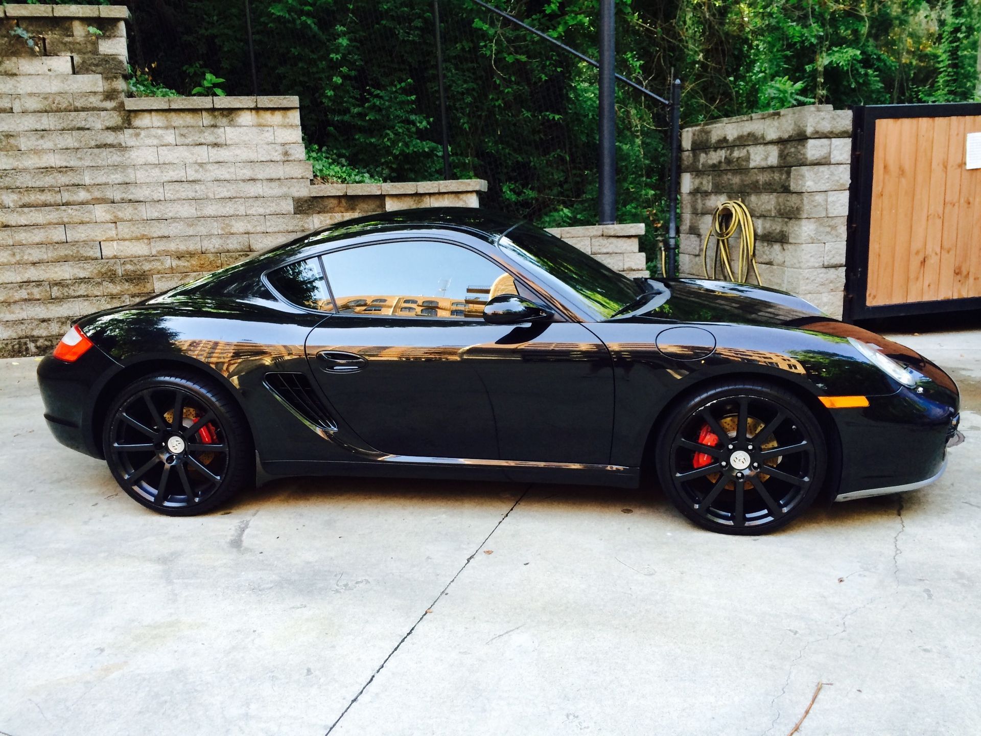 A black sports car is parked in a driveway
