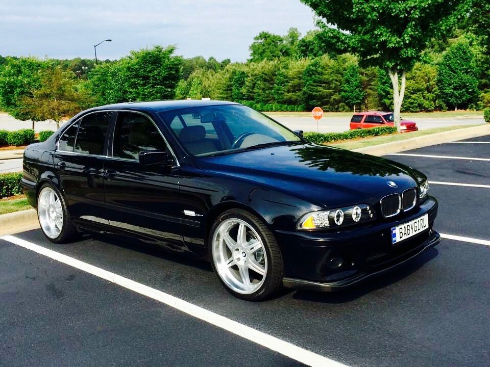 A black BMW is parked in a parking lot