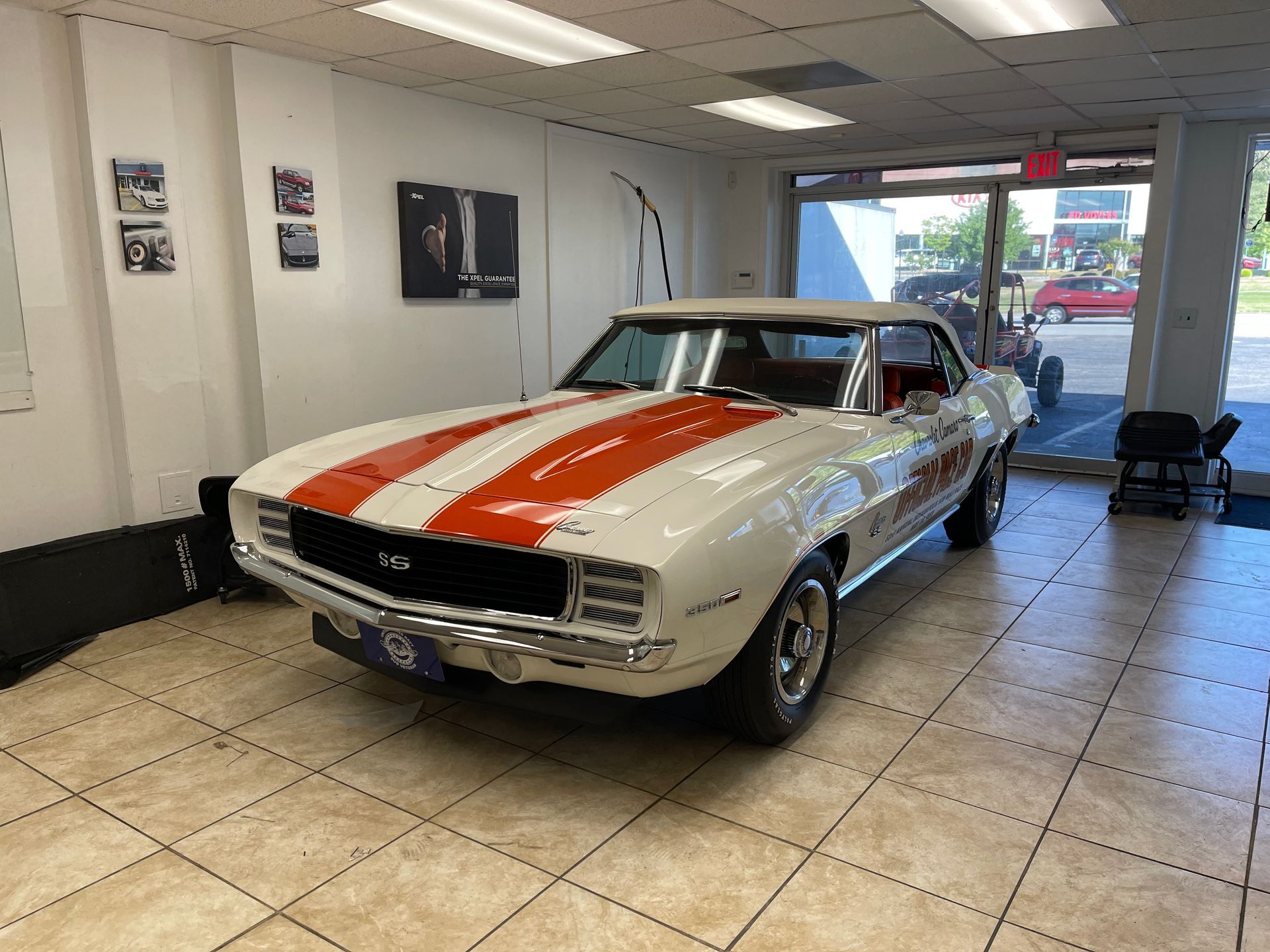 A white and orange Chevrolet Camaro is parked in a showroom.