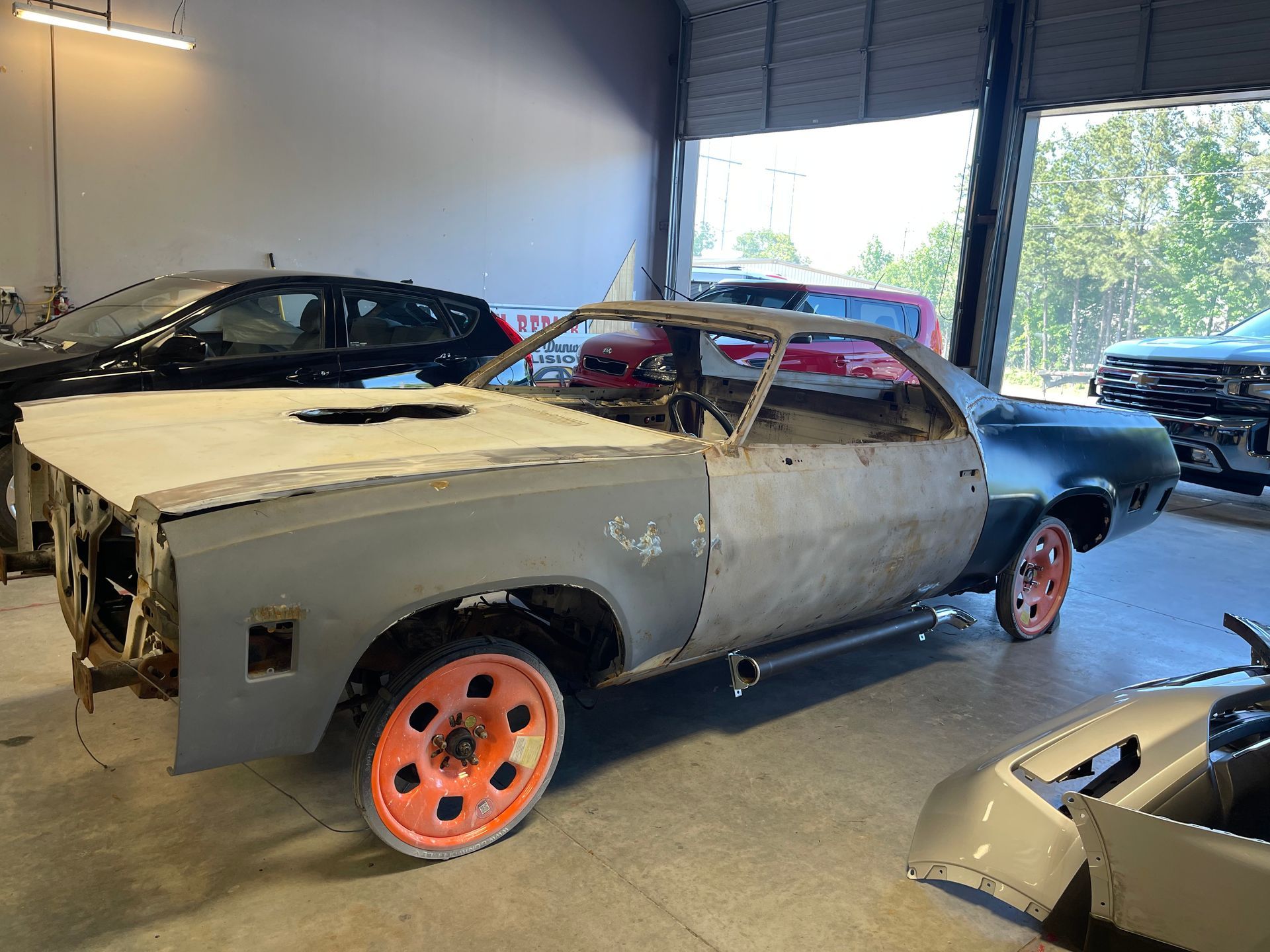 A car with orange wheels is sitting in a garage