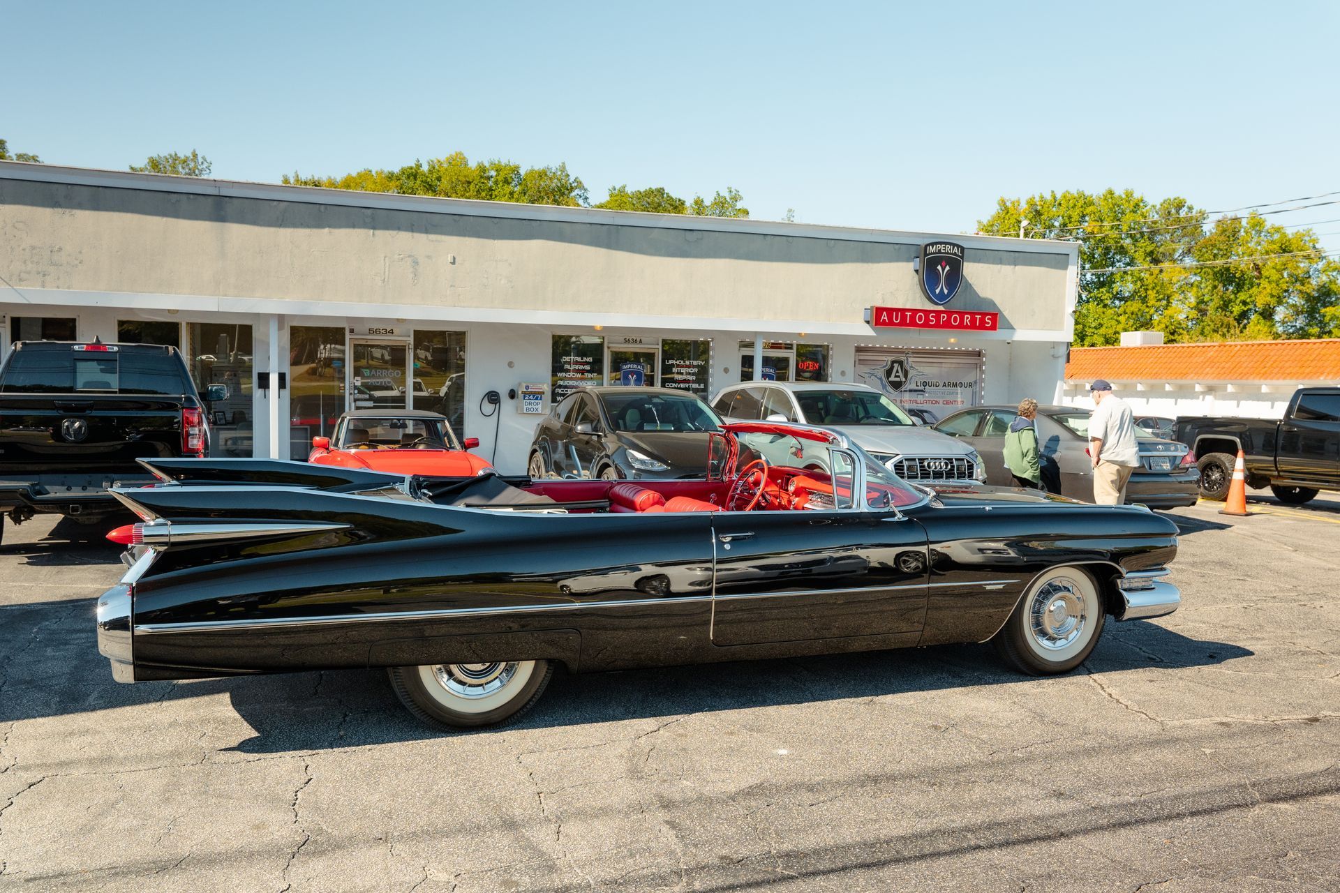 A black Cadillac is parked in front of a building
