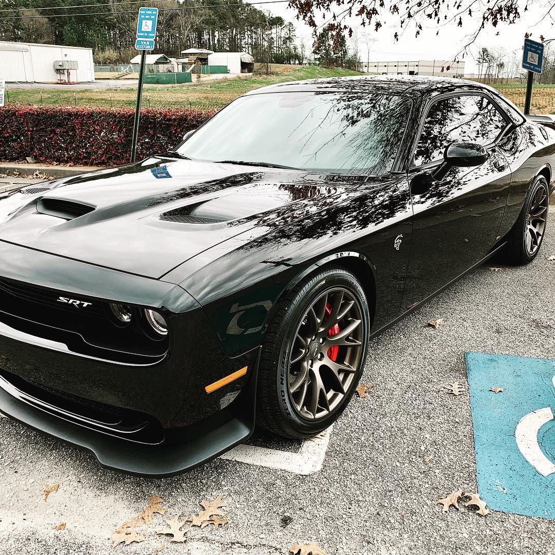 A black Dodge Challenger is parked in a parking lot