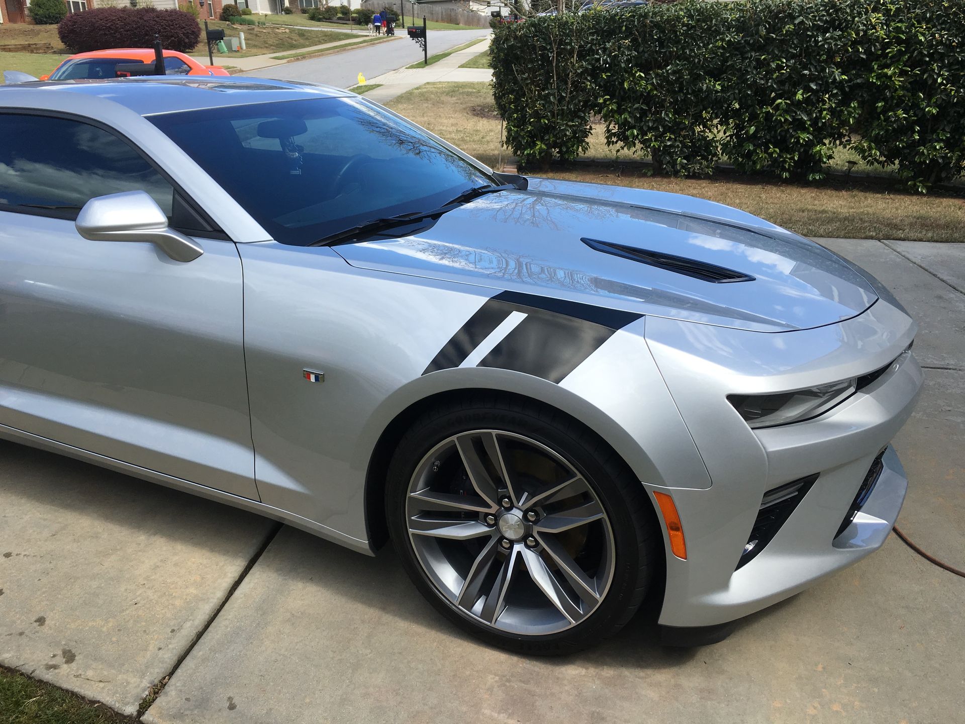 A silver sports car is parked on the side of the road