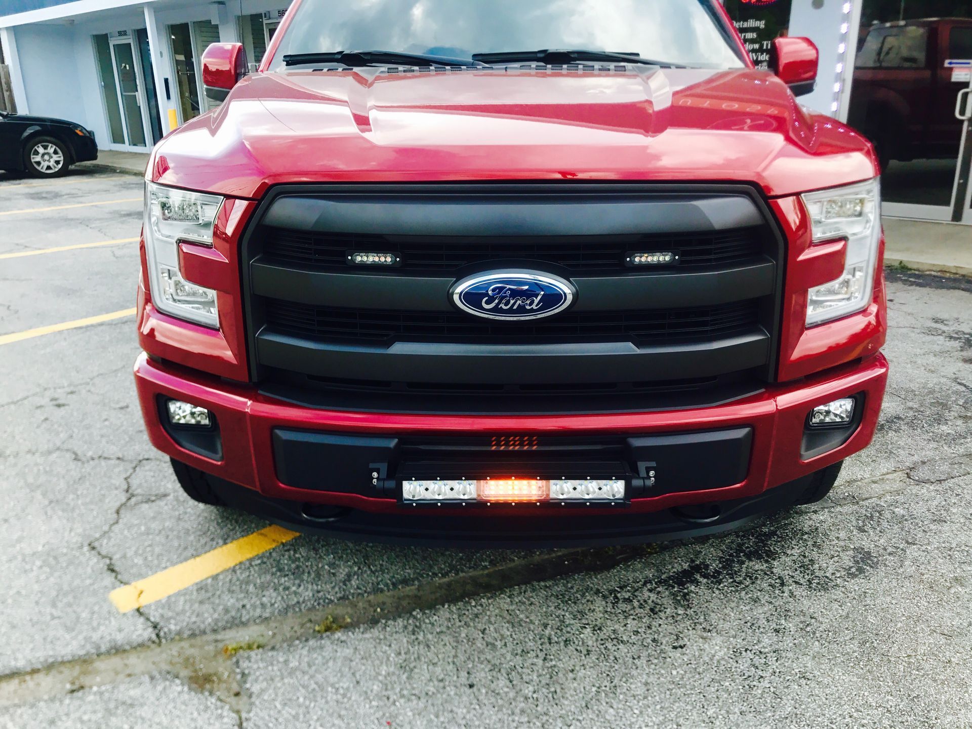 A red ford truck is parked in a parking lot