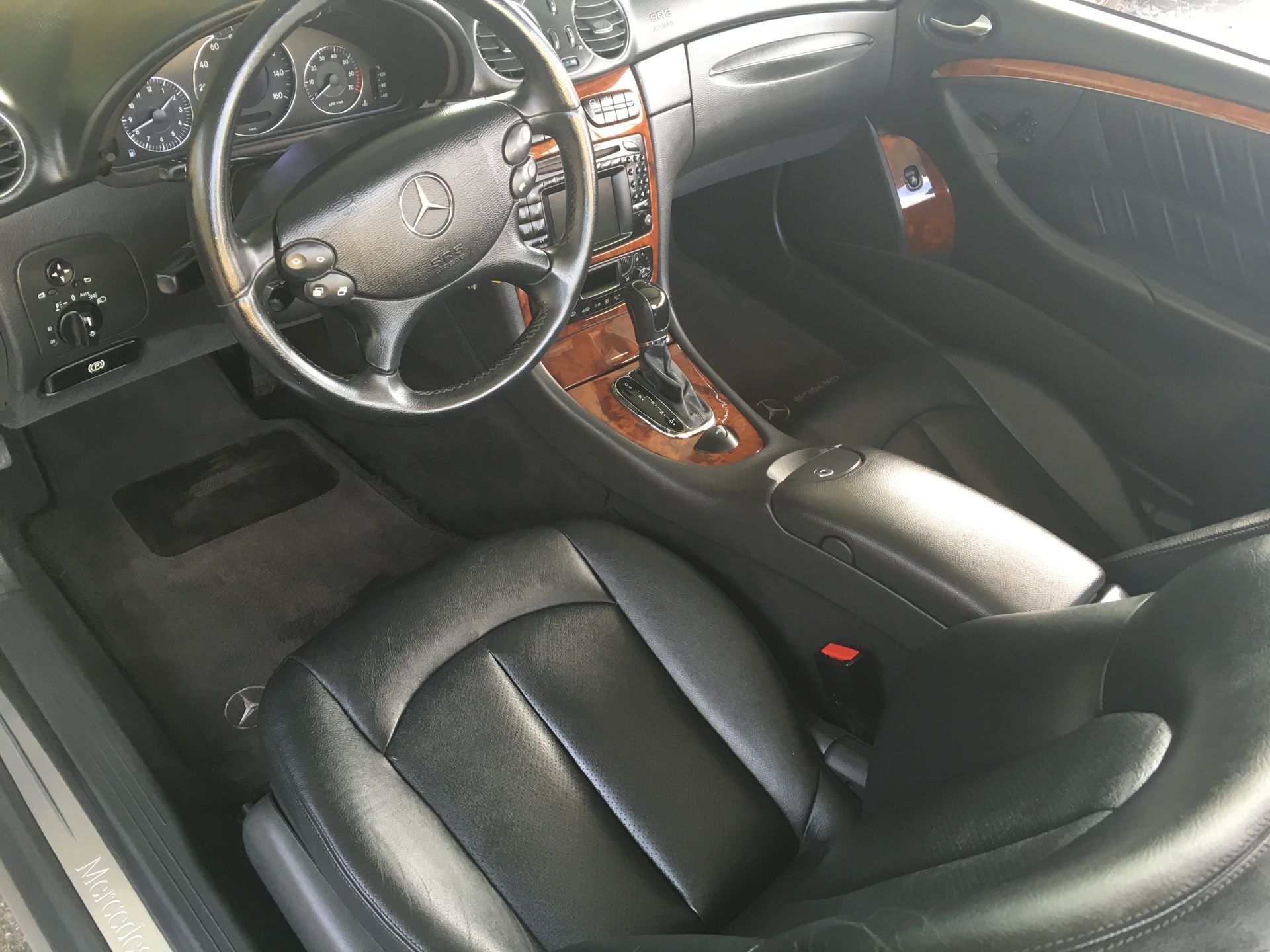The interior of a car with black leather seats and a steering wheel