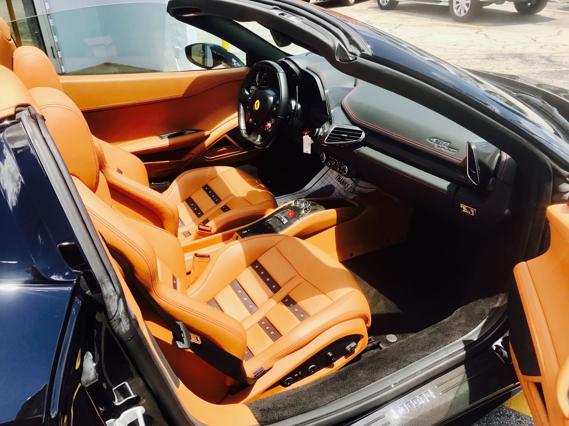 The interior of a Ferrari sports car with the top down