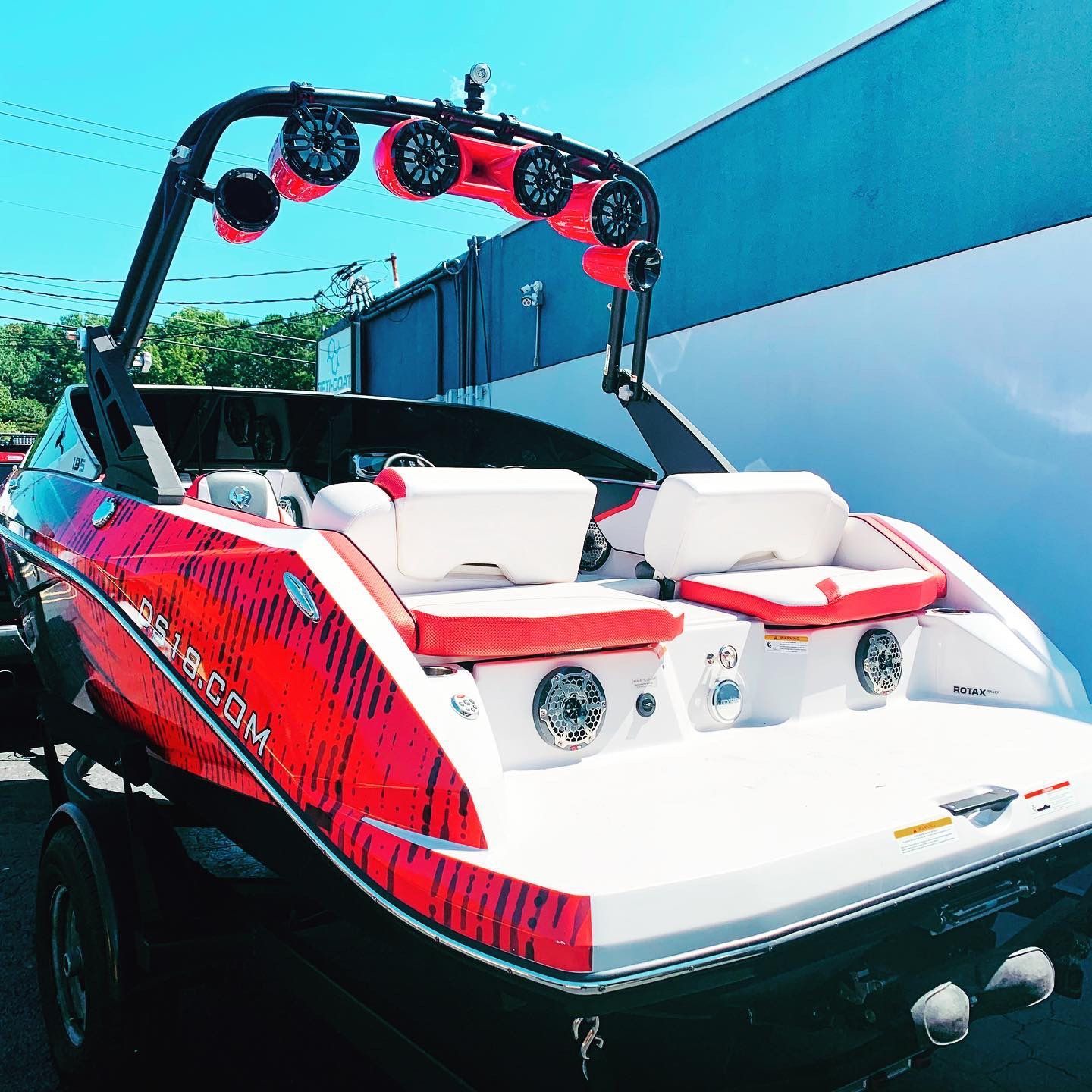 A red and white boat is parked in front of a building