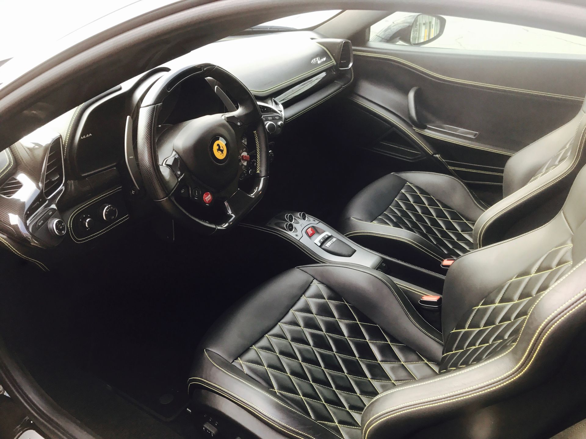 The interior of a Ferrari sports car with black seats