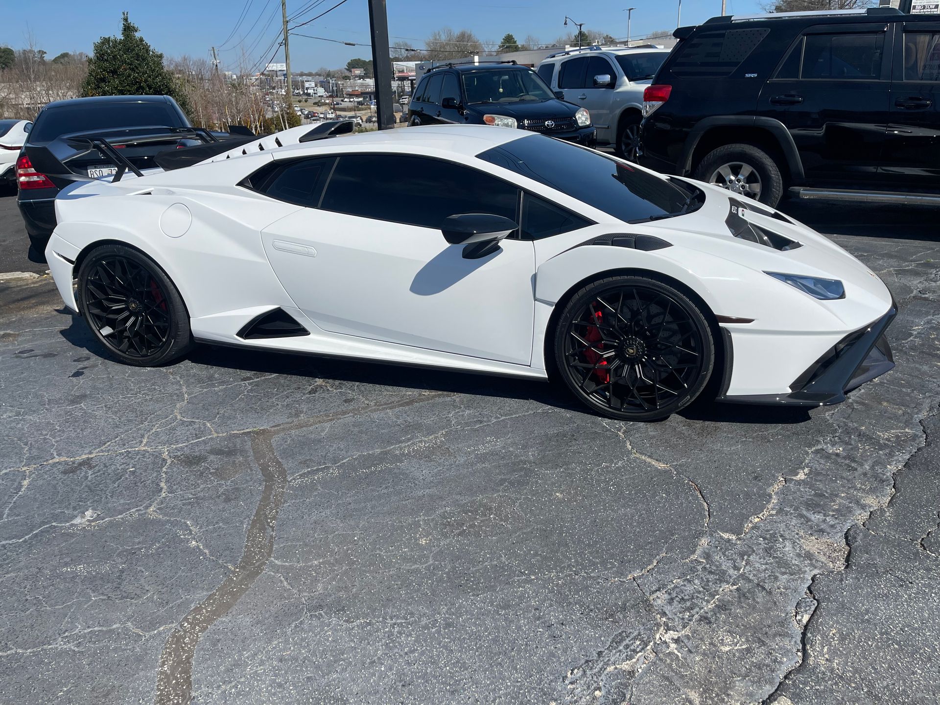 A white Lamborghini Huracan is parked in a parking lot