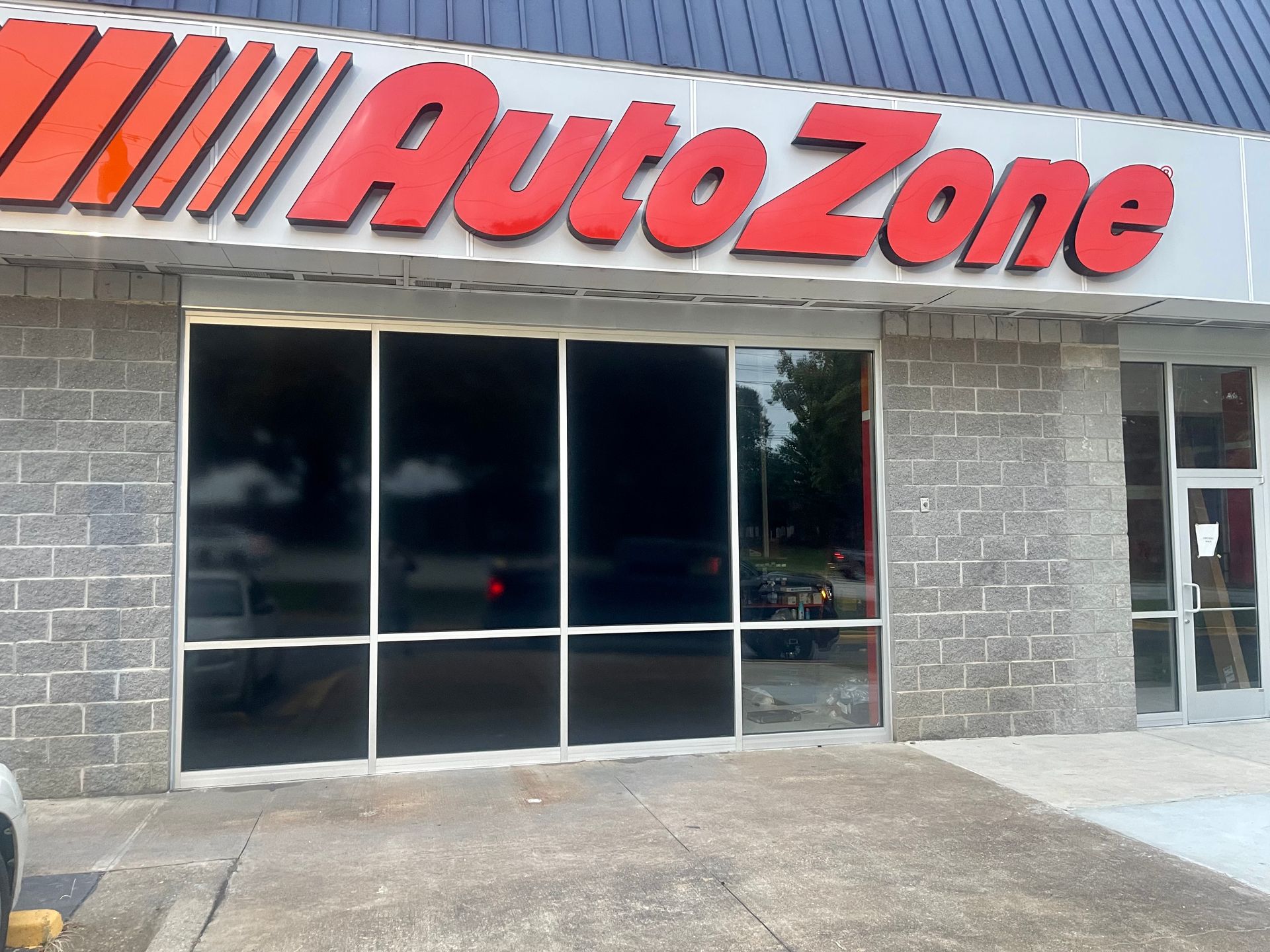 A car is parked in front of an Autozone Store