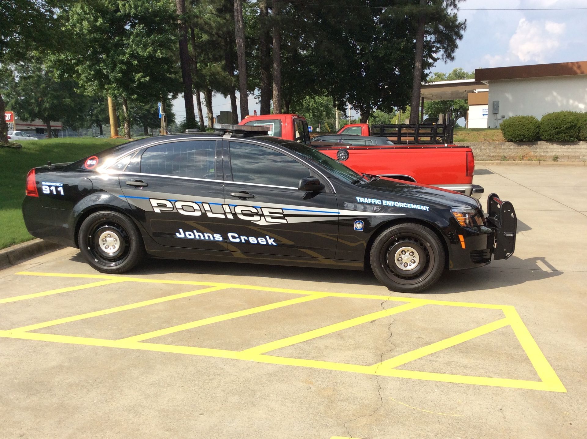 Black police car is parked in a parking lot