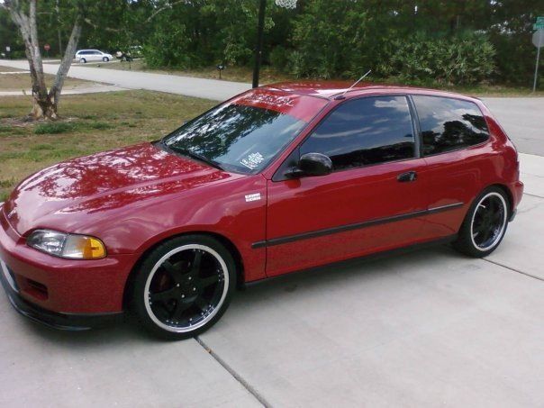 A red car is parked on the side of the road