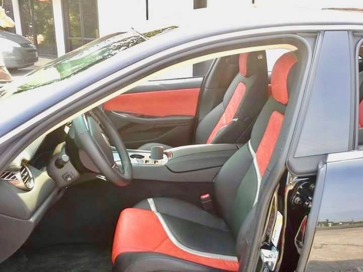 The inside of a car with red and black seats