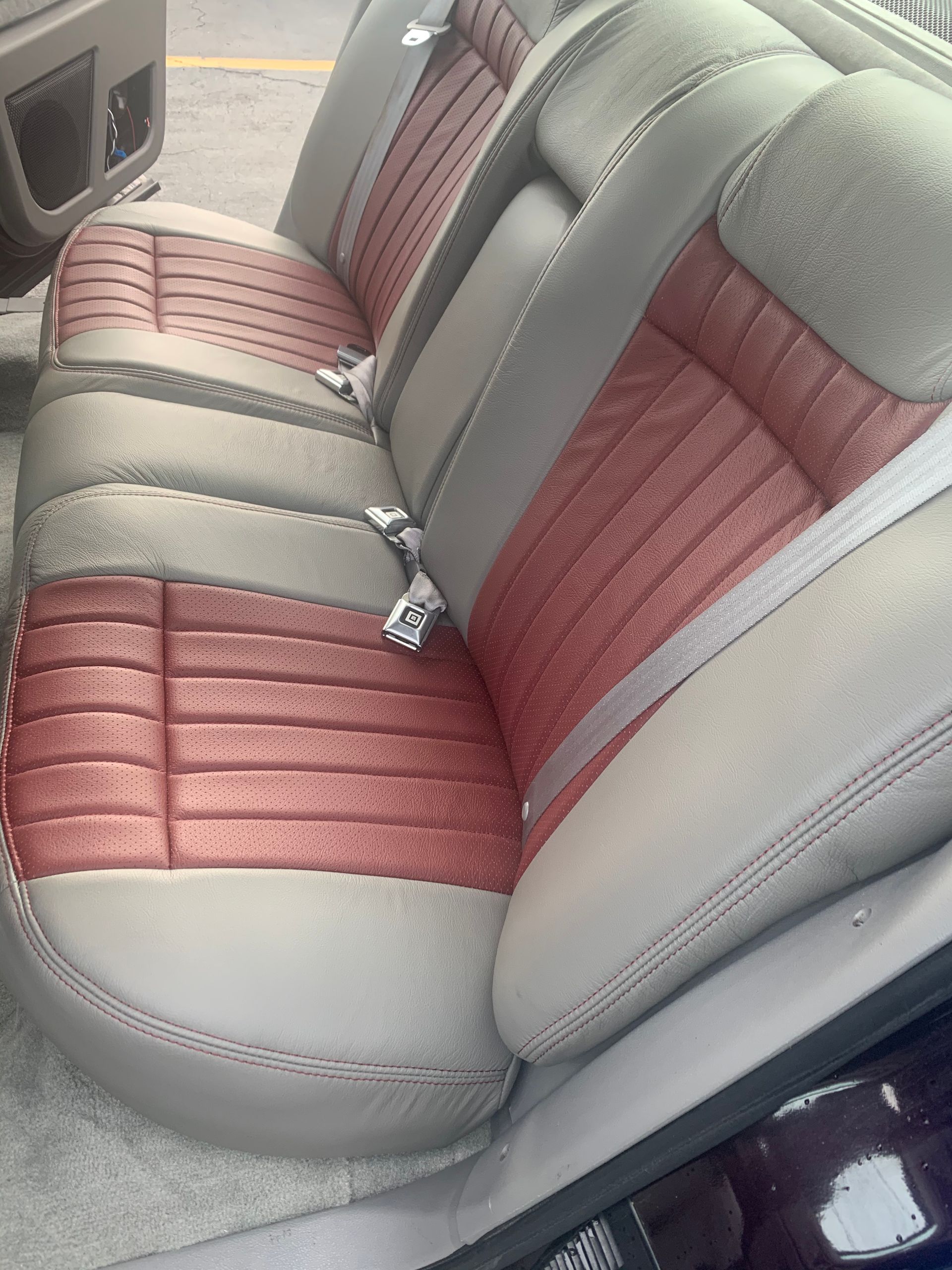 The back seat of a car with red and grey seats