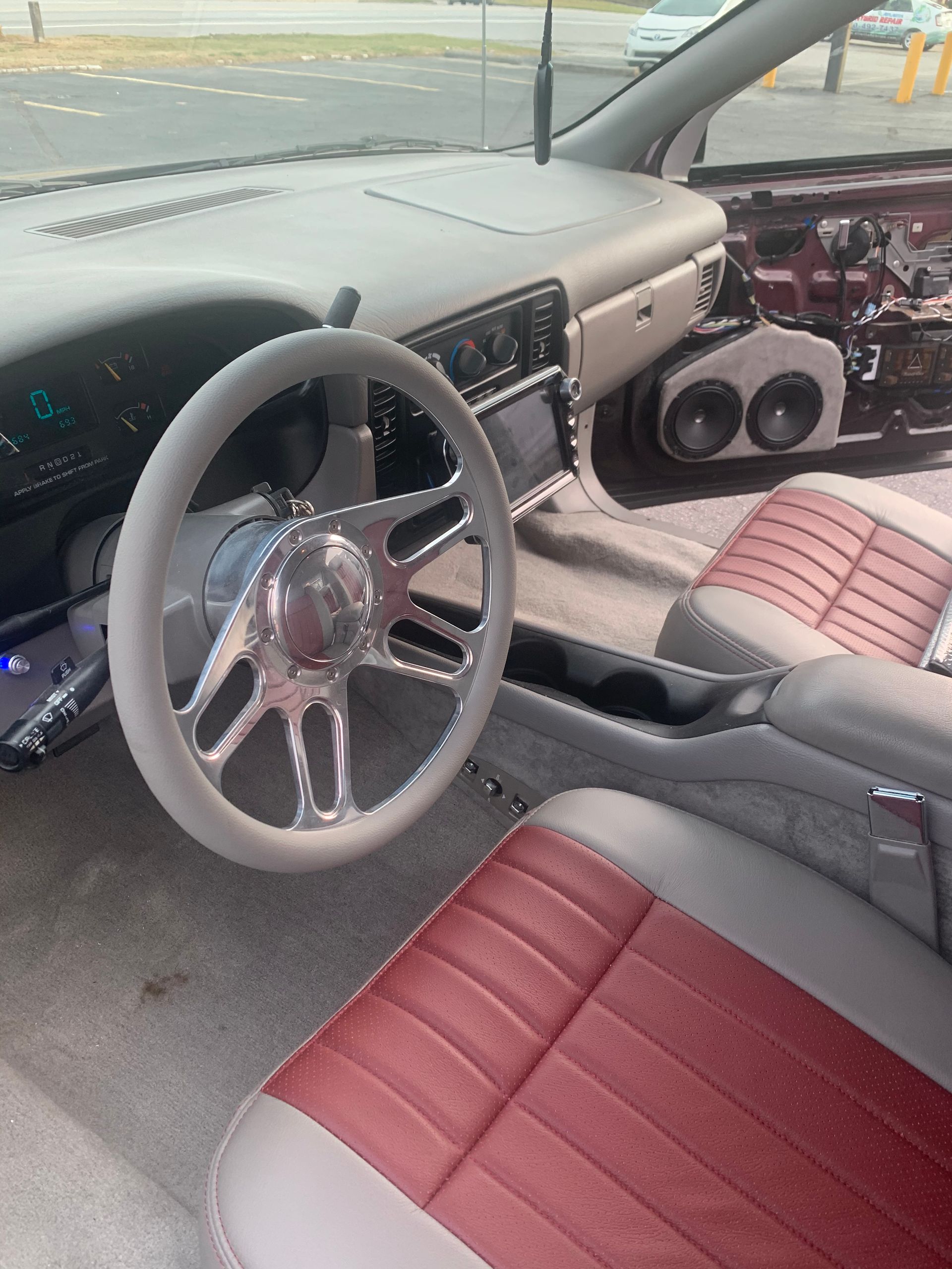 The inside of a car with a steering wheel and red seats