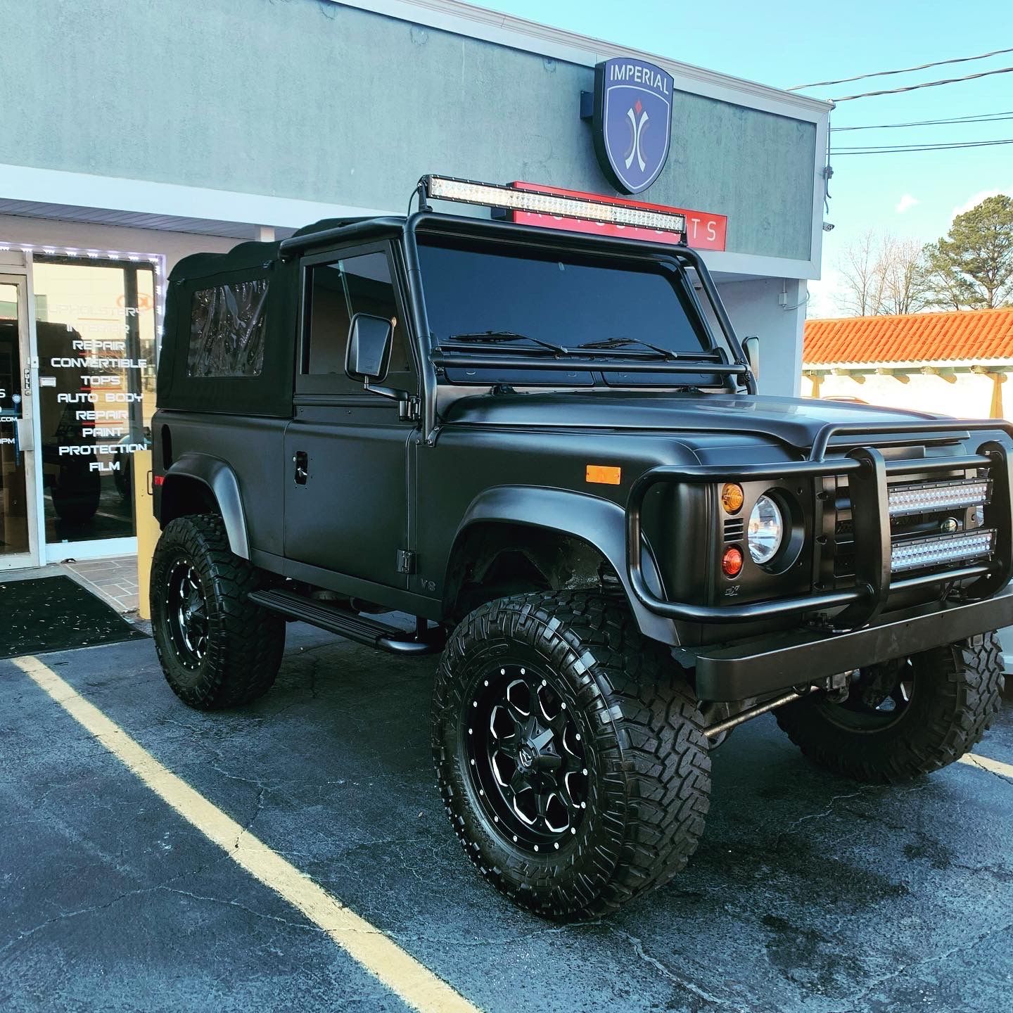 A black Jeep is parked in front of a building
