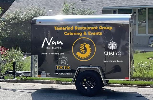 A tamarind restaurant group trailer is parked on the side of the road