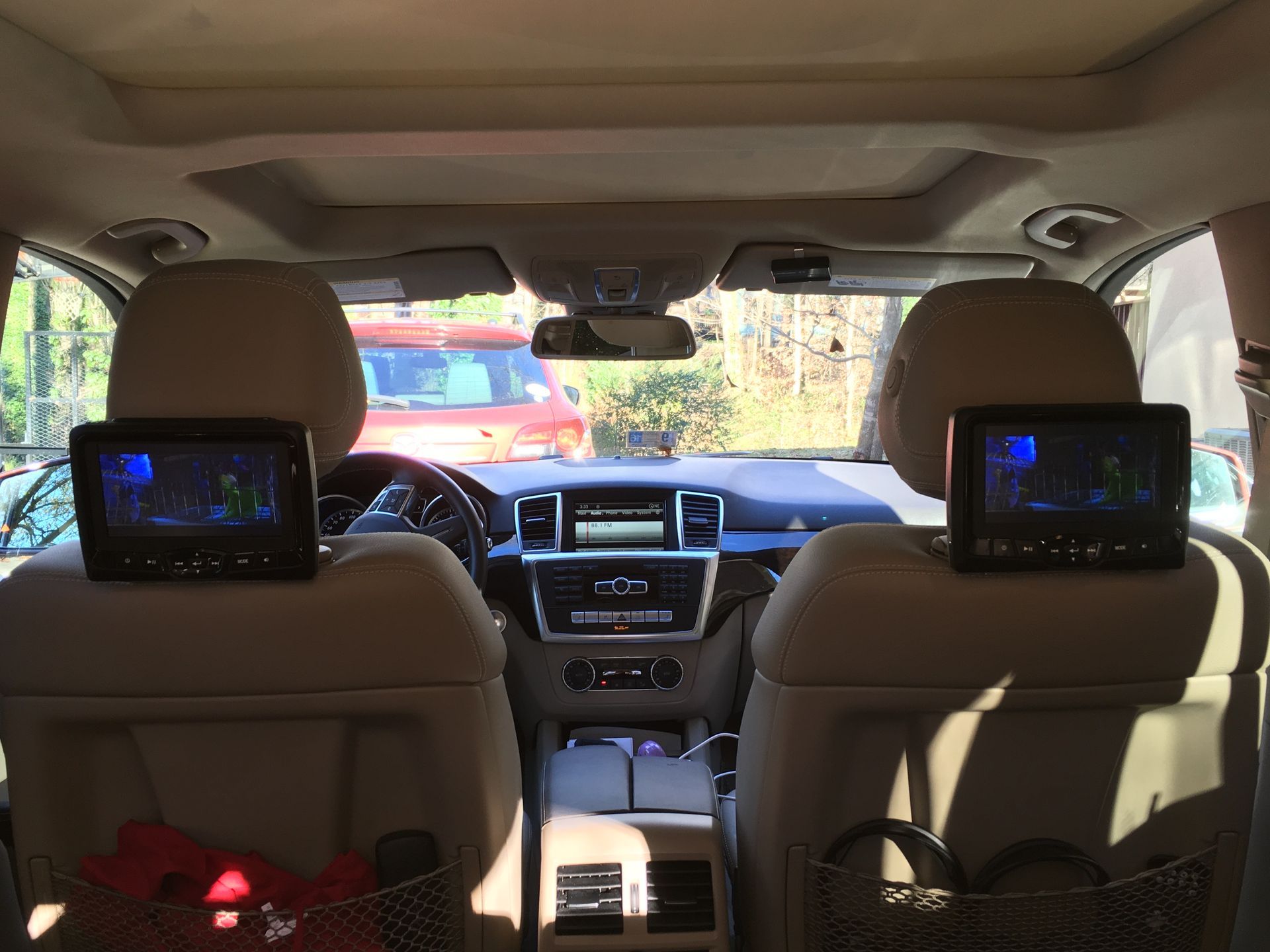 The back seat of a car with two headrest monitors