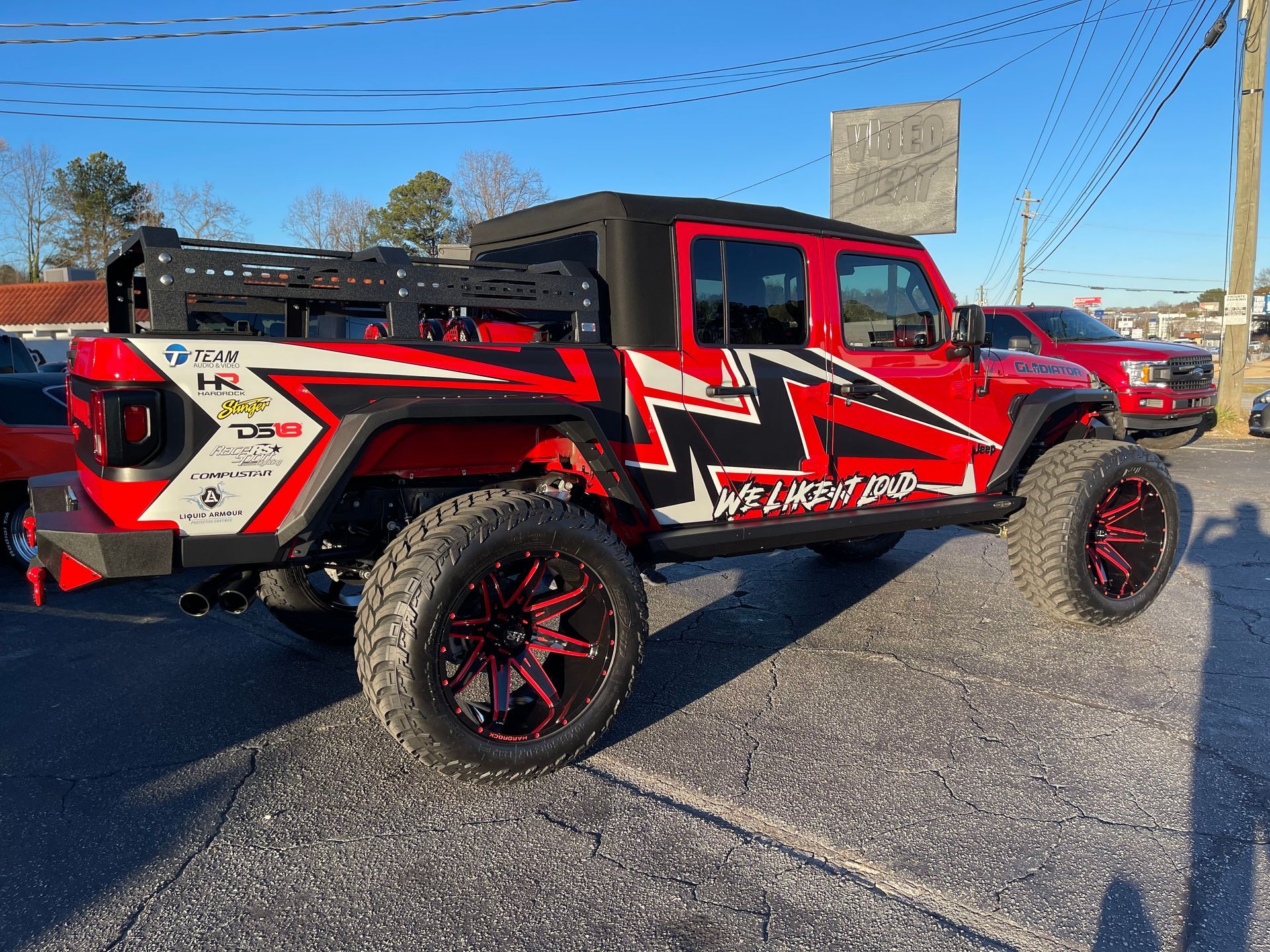 A red jeep is parked on the side of the road