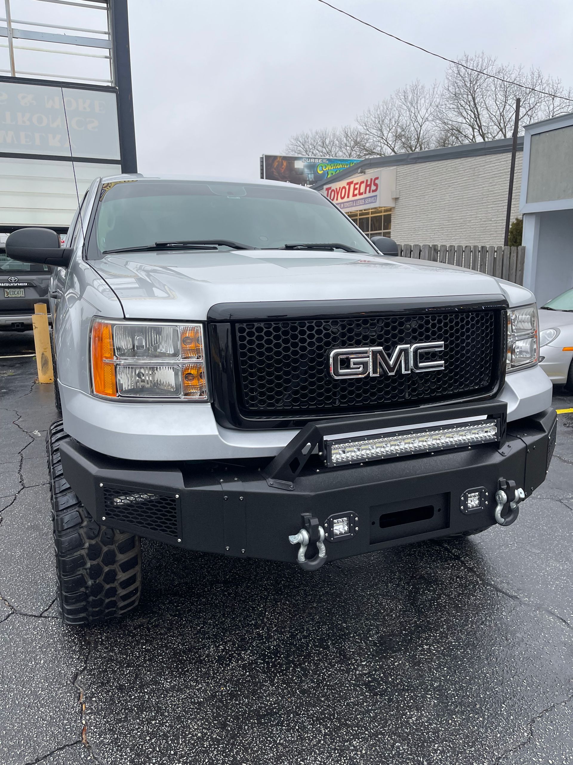 A silver GMC truck is parked in a parking lot
