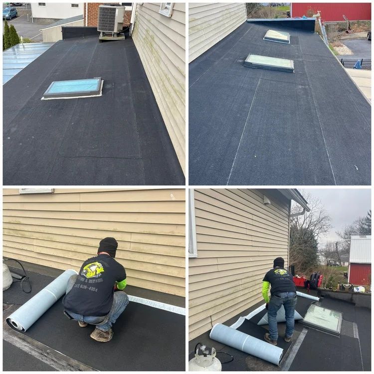 Roofing crew installing black underlayment around skylights on a sloped house roof