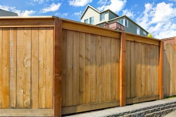 A wooden fence with a house in the background.