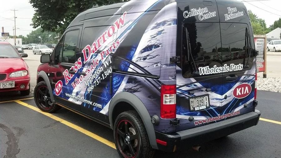 Black van with custom wrap, parked in lot; Arrow Collision Repair advertisement.