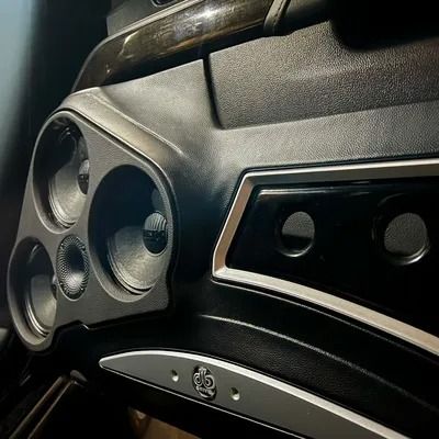 Motorcycle dashboard with speaker array and black and silver trim.