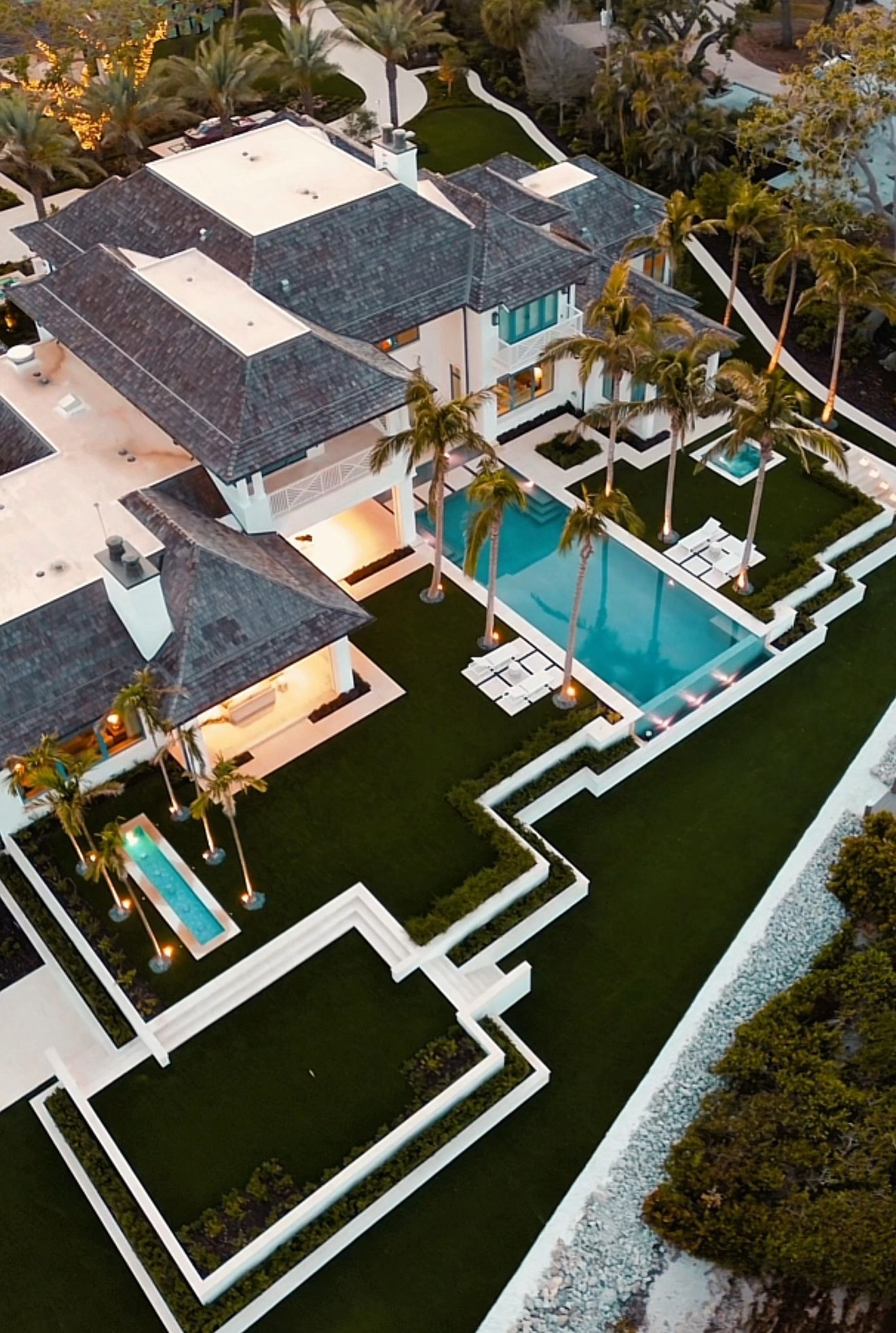 An aerial view of a large house with a swimming pool in the backyard.