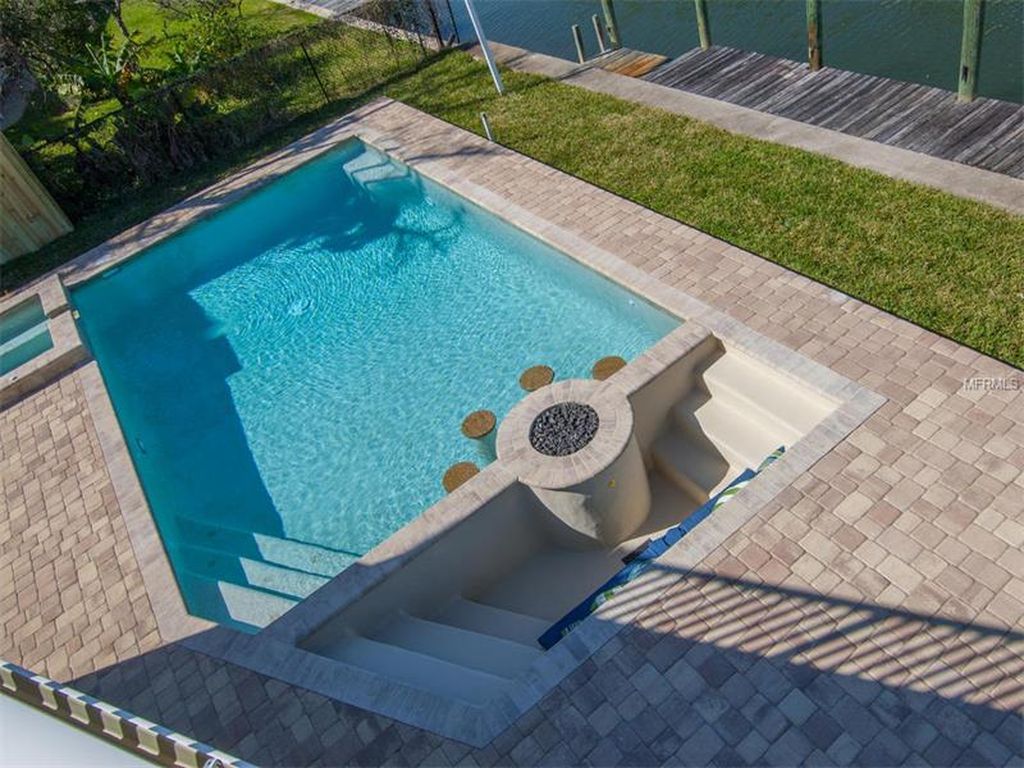 An aerial view of a swimming pool with a fire pit