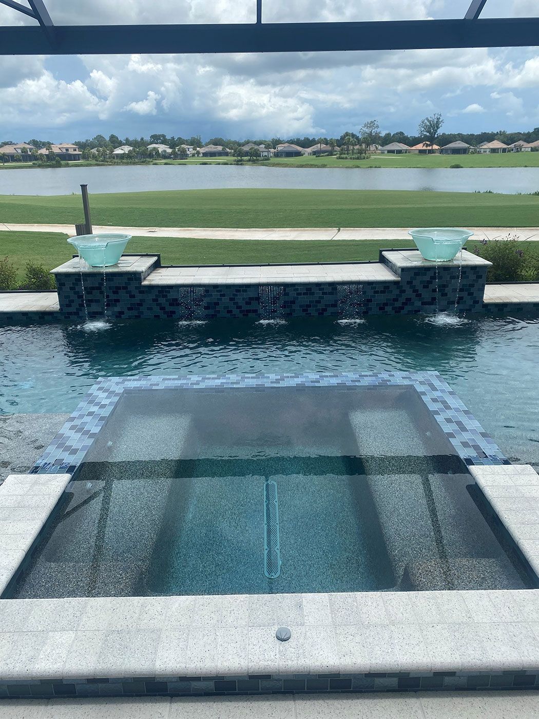 A large swimming pool with a view of a lake.