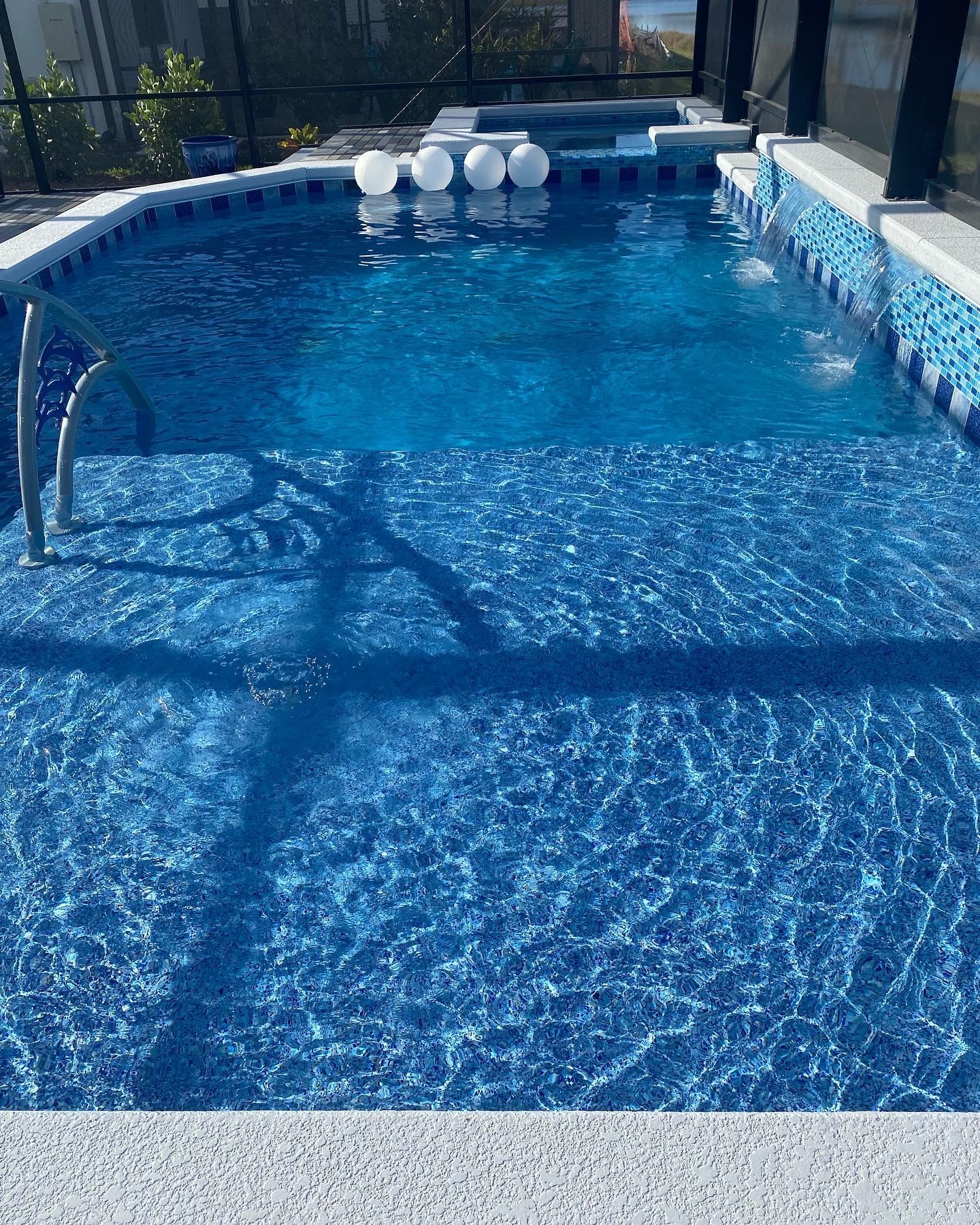 A large swimming pool filled with blue water and a ladder.