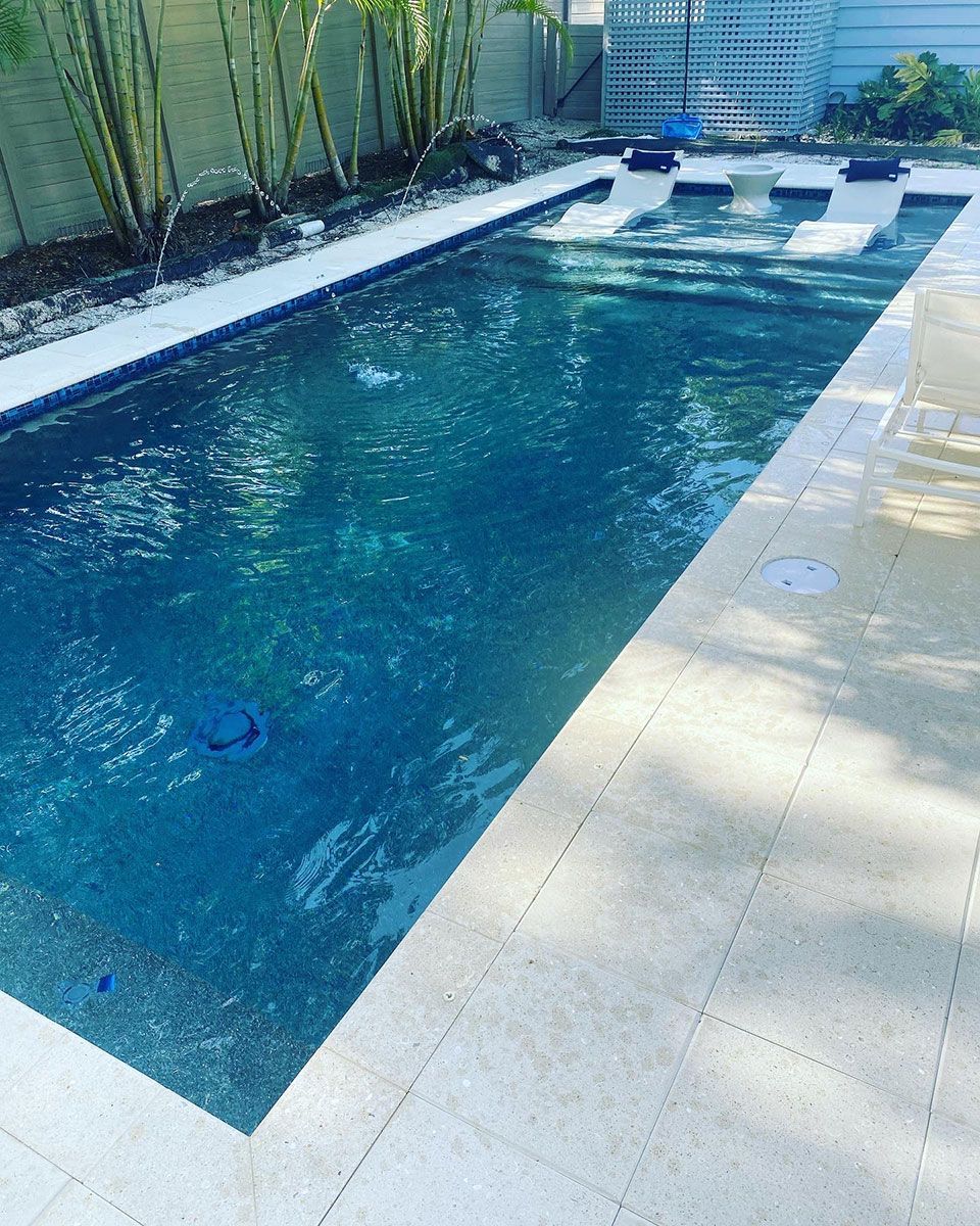 A large swimming pool with a fountain in the backyard