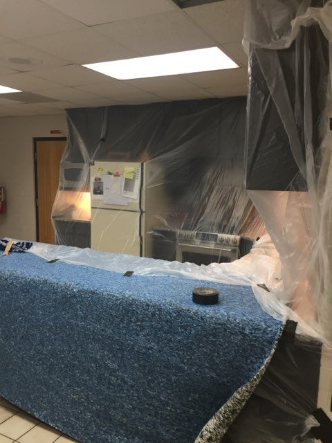 a kitchen is covered in plastic and a blue blanket