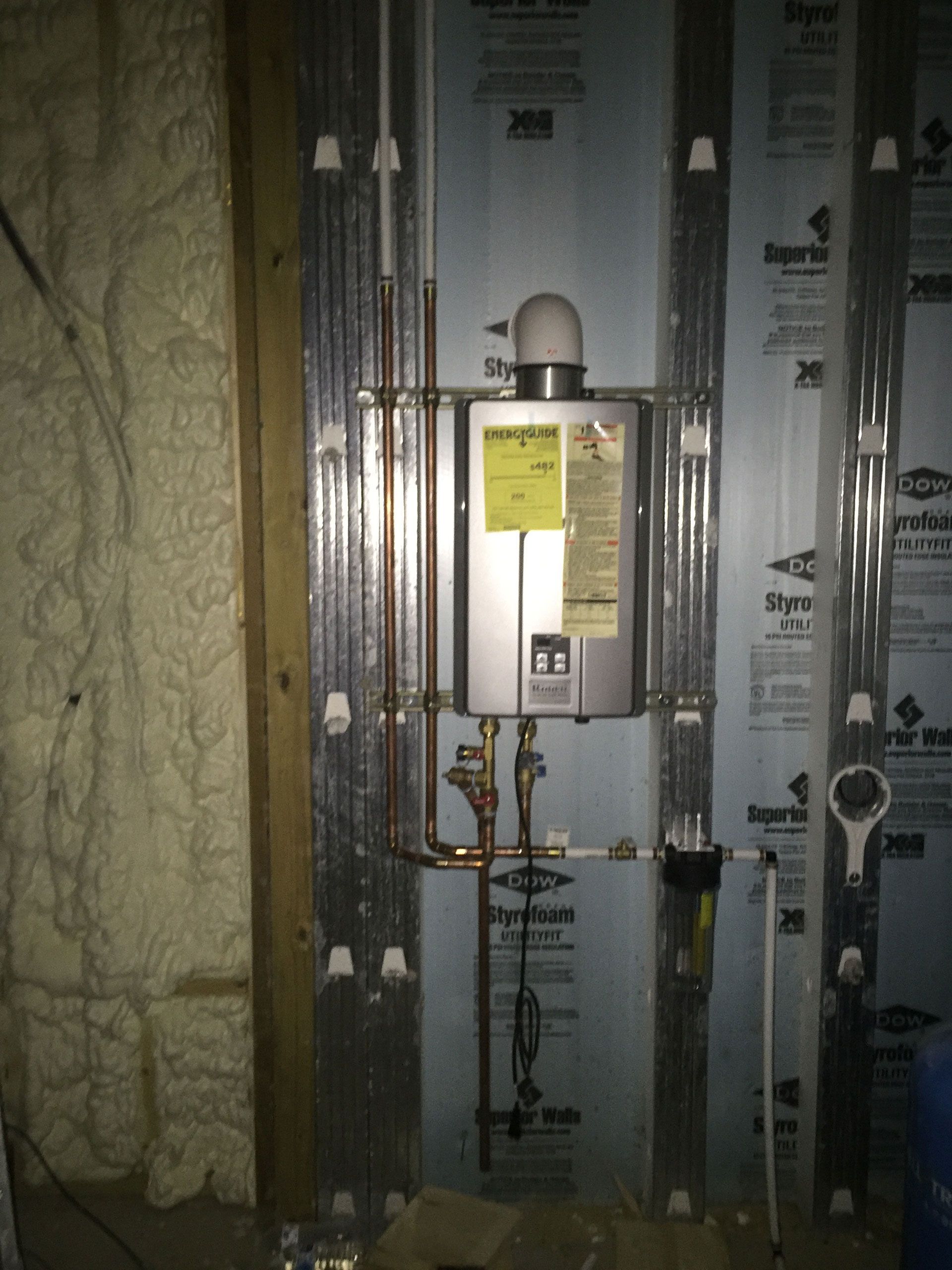 a water heater with a yellow sticker on it