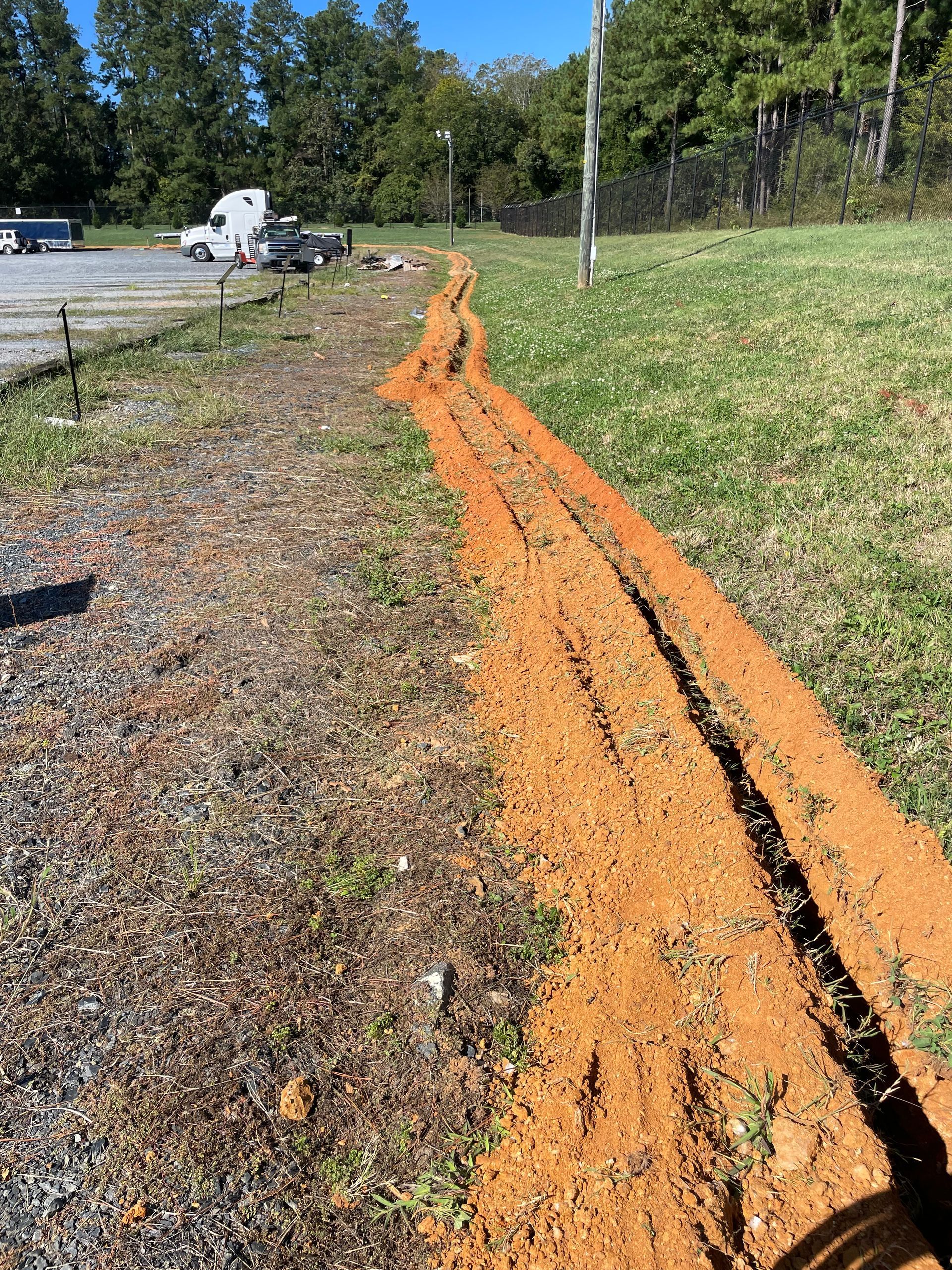 Using a trencher to dig a hole in the ground .
