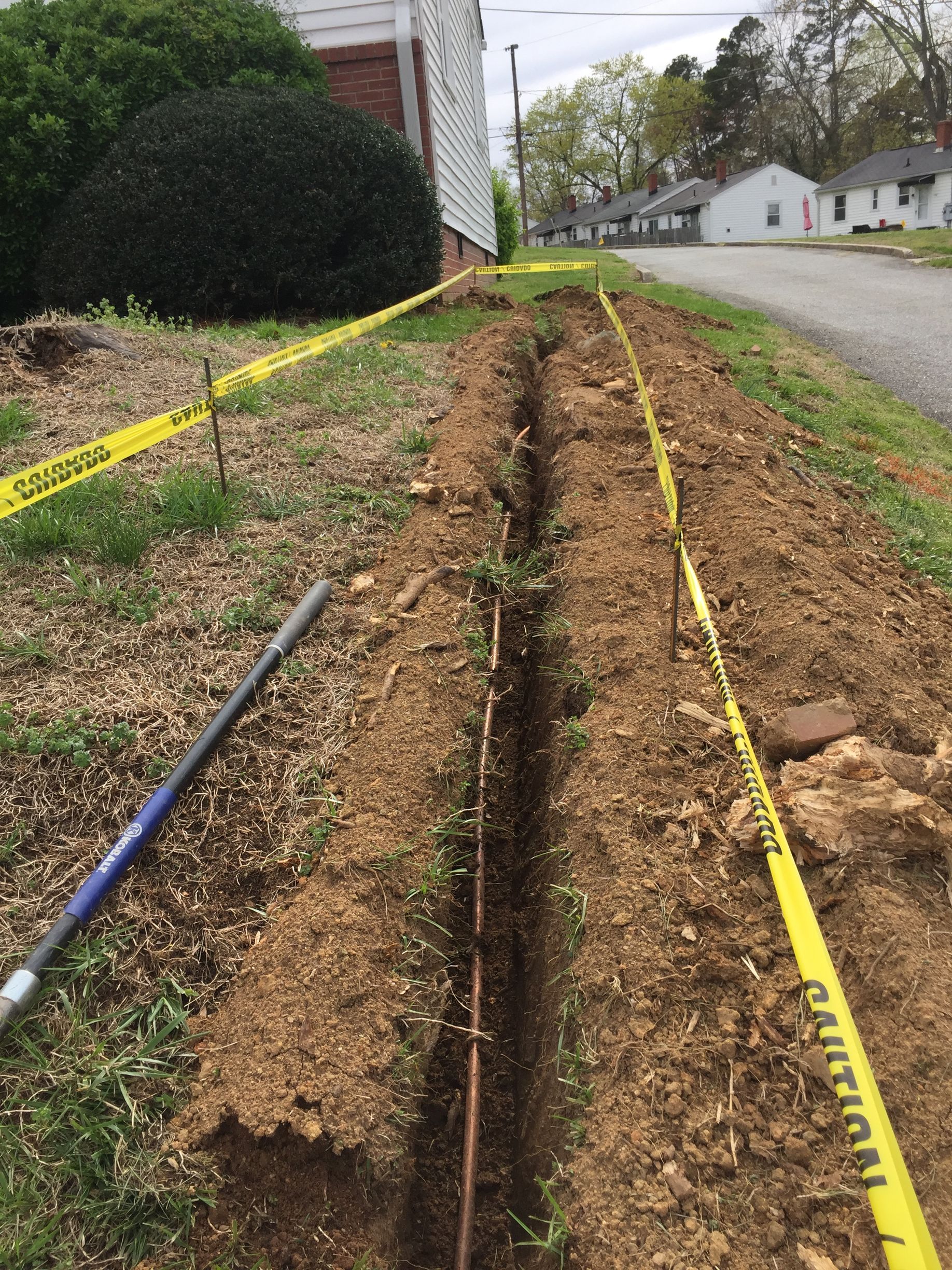 a yellow caution tape is covering a hole in the ground .