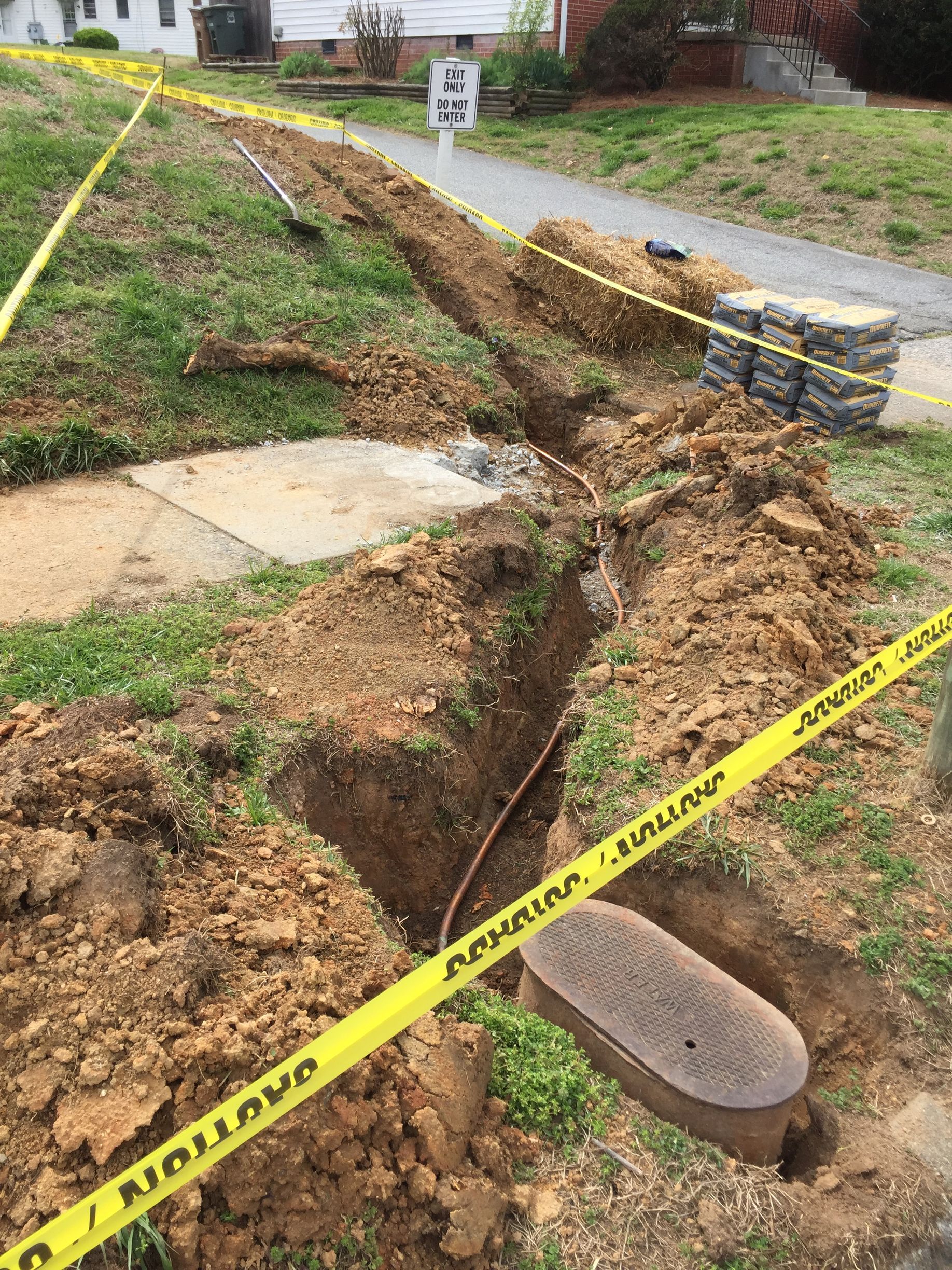 a yellow caution tape is covering a hole in the ground .