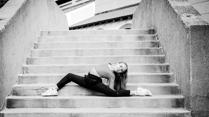 A woman is doing a split on a set of stairs.
