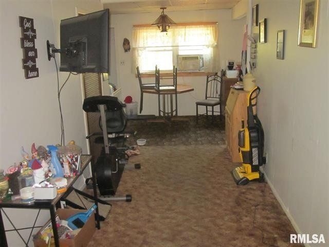 A living room with a yellow vacuum cleaner and a flat screen tv