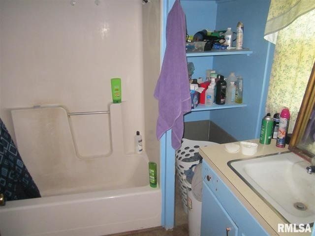 A bathroom with a sink and a bathtub and a rmlsa logo