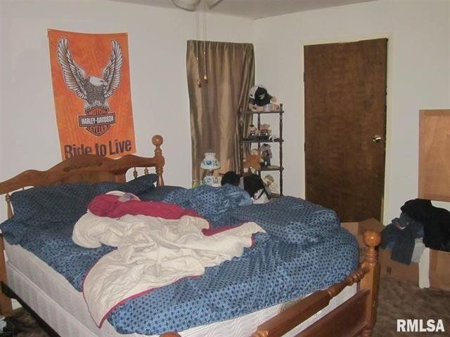 A bedroom with a harley davidson poster on the wall