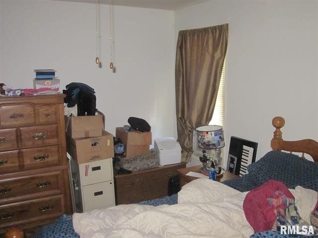 A bedroom with a bed and a dresser that says rmlsa on it