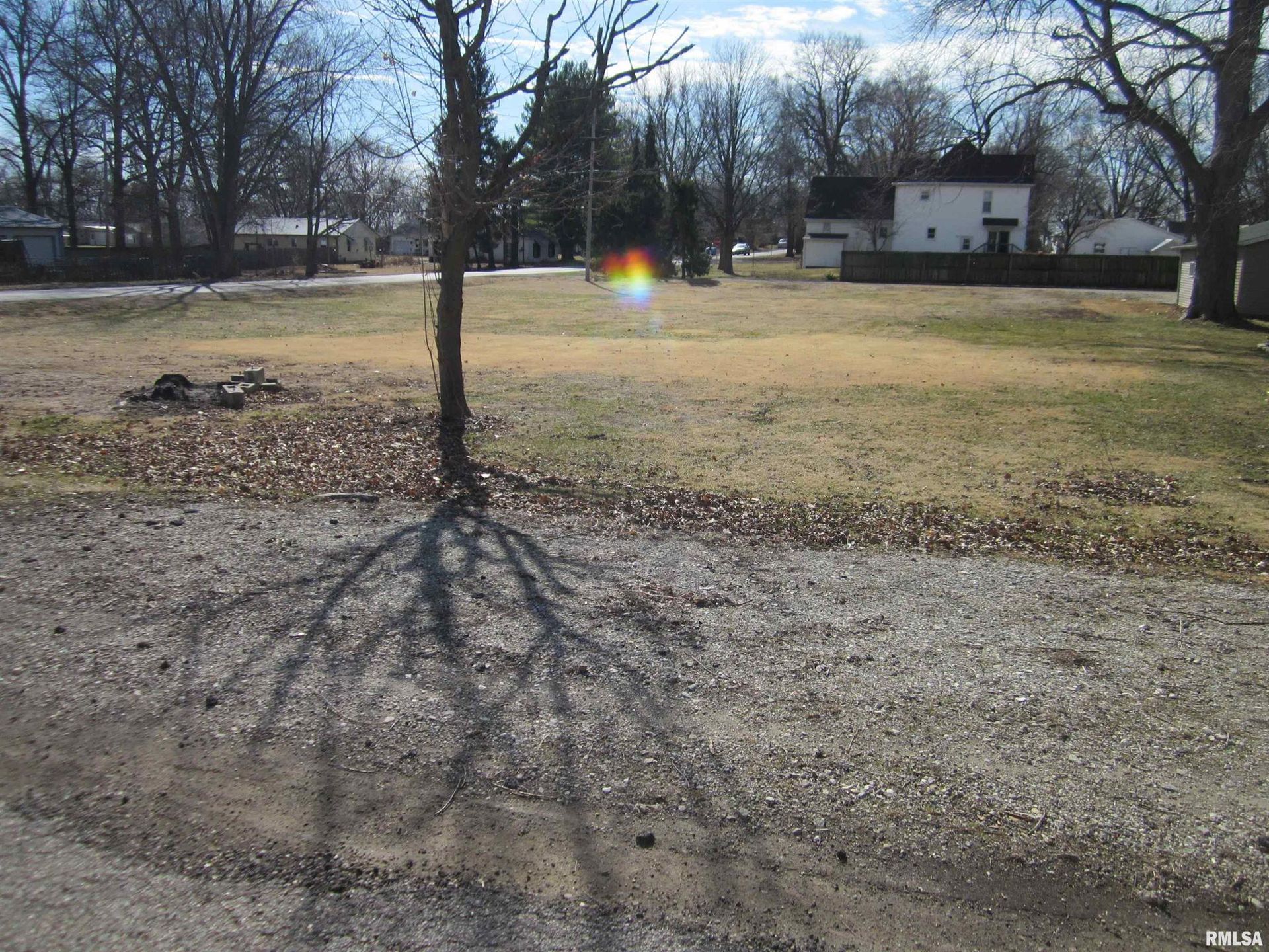 Blue and white ranch-style house with a single-car garage. Brown grass in the front yard. Bare trees in the background.