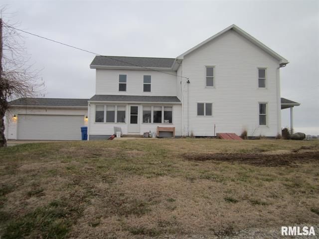 A large white house with a garage is for sale.