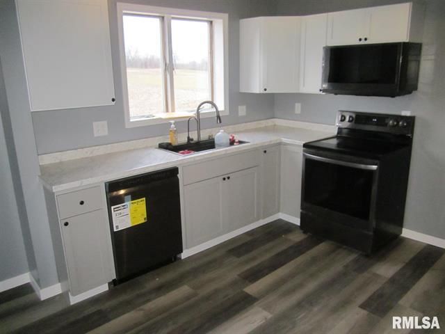 A kitchen with white cabinets and a black stove